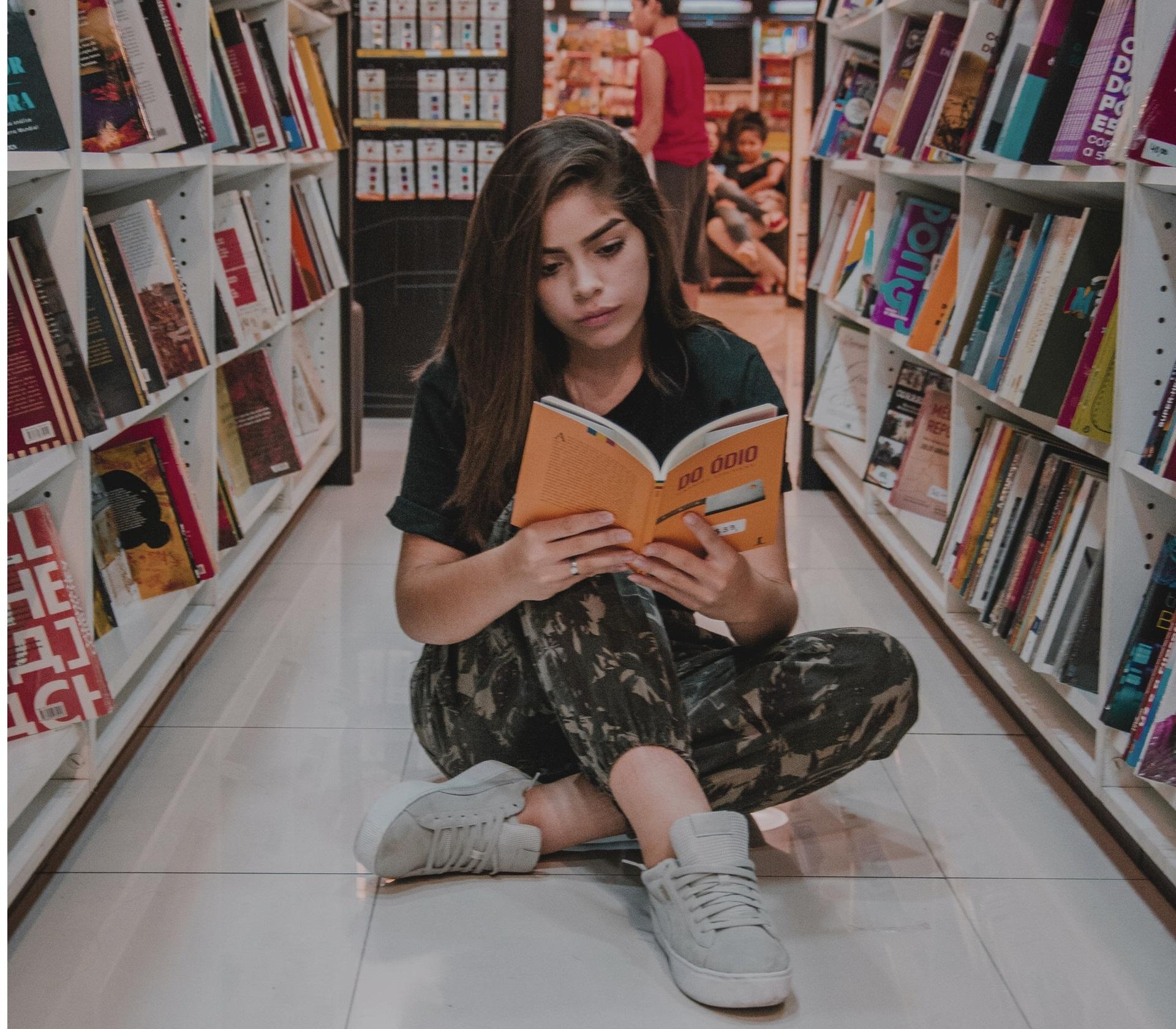 Vrouw leest boek in de bibliotheek